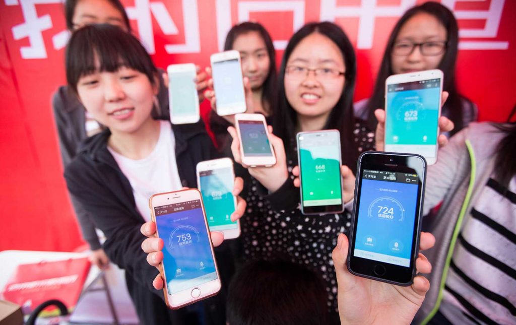 Chinese women show the scores of their Zhima Credit of Alibaba's Ant Financial on their Apple iPhones in Hangzhou City on May 9, 2016. (AP / Imagechina)
